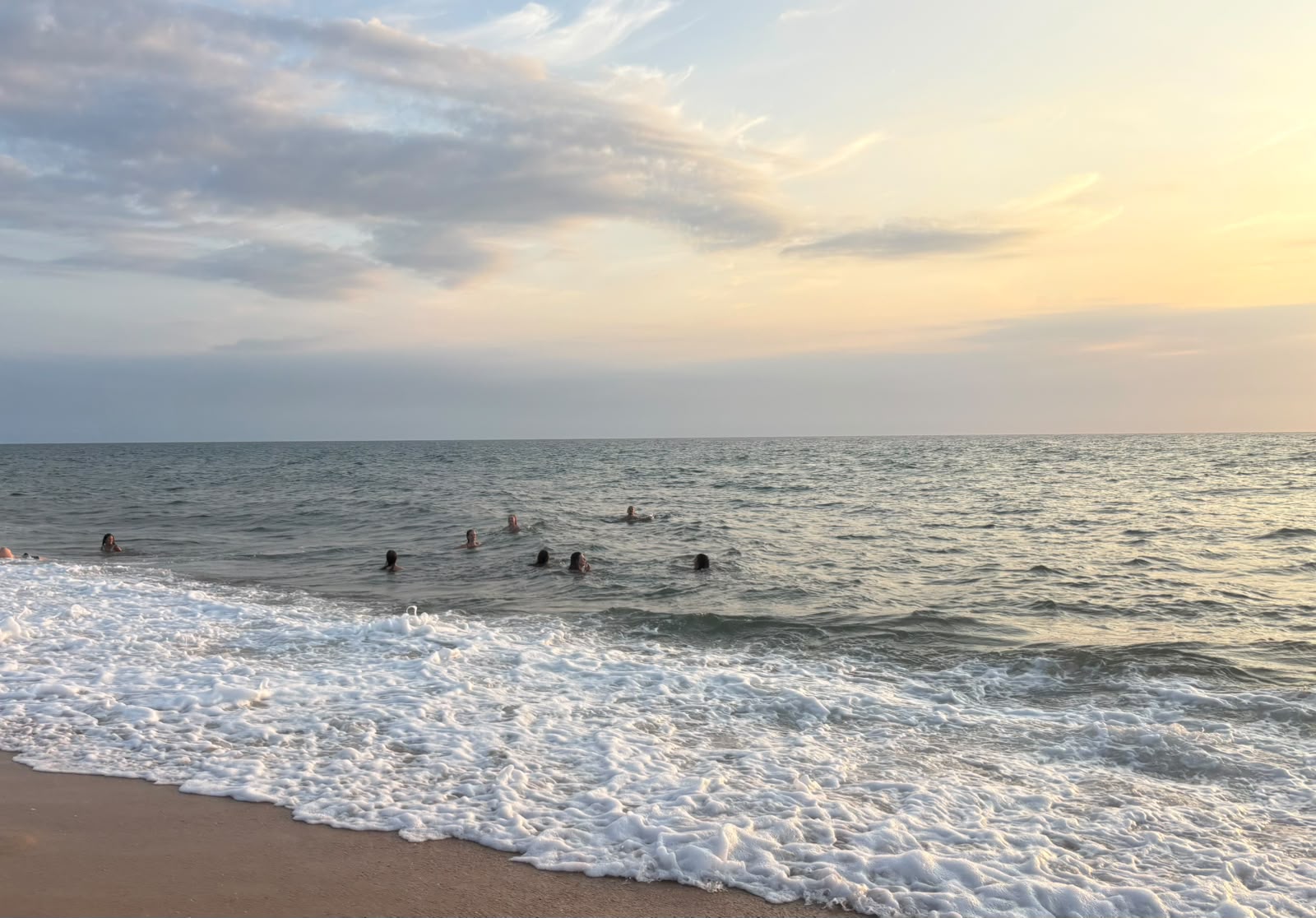 Fotografie von Anika Yago – Schwimmende im Meer bei Sonnenuntergang