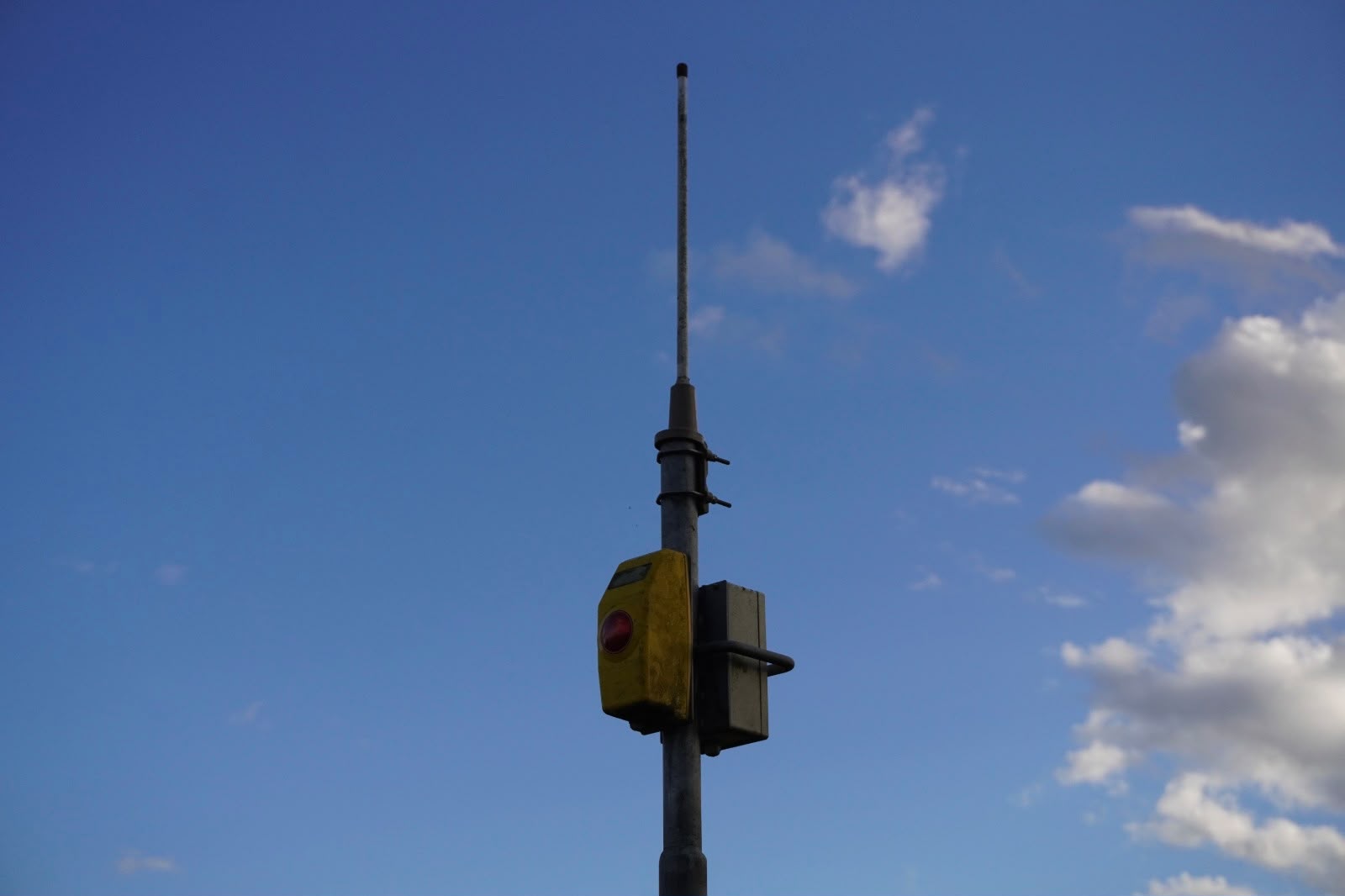Fotografie von Anika Yago – Ampel-Druckknopf vor blauem Himmel